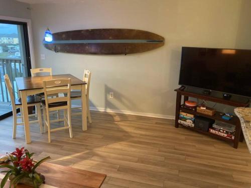 a dining room with a table and a television at Jimmy's Beach Condo in Emerald Isle