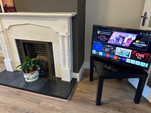 a living room with a fireplace and a tv at The Perfect Place in Ennis