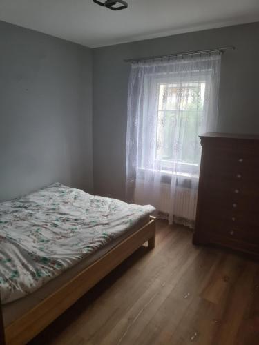 a bedroom with a bed and a dresser and a window at Apartament mieszkanie do wynajęcia Justyna in Walim