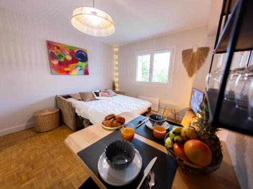 une chambre avec un lit et une table avec des fruits dessus dans l'établissement Le Trésum - Lac et vieille ville, à Annecy