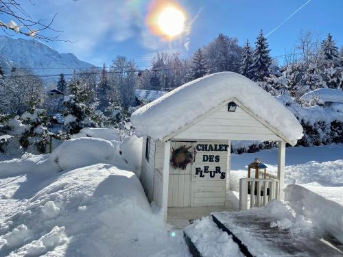 un petit hangar recouvert de neige avec le soleil derrière dans l'établissement Chalet Soleil Blanc au pied des pistes, à Saint-Gervais-les-Bains