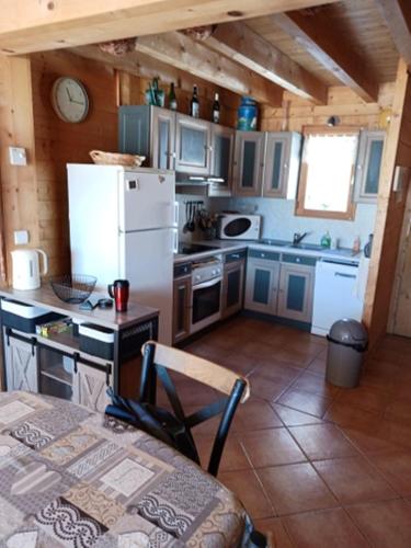 - une cuisine avec un réfrigérateur et une table dans la chambre dans l'établissement Chalet la Chaumière, à Hauteluce