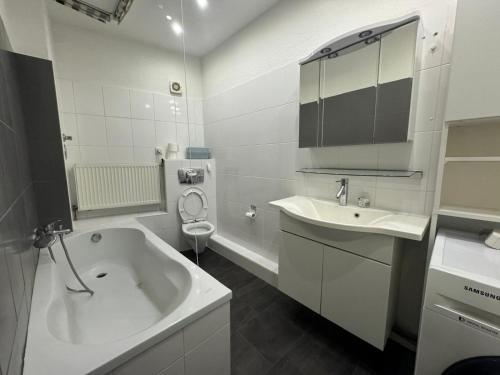 Un baño con bañera, lavabo e inodoro. en Best Frankfurt Apartments, en Frankfurt
