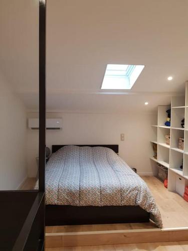 une chambre avec un lit et une lucarne dans l'établissement Appartement 2 pièces avc piscine, à Villeneuve-Loubet