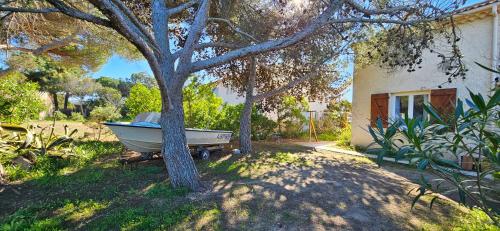 a boat sitting in a yard next to a house at T3 Paradisiaque sur la plage, les pieds dans l'eau in Olmeto