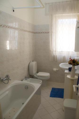 a bathroom with a tub and a toilet and a sink at Summer apartment in Viareggio