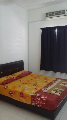 a bedroom with a bed with a colorful blanket at The Simple Homestay in Simpang Pulai