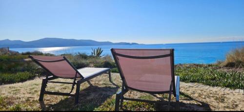 deux chaises assises sur le sable près de l'eau dans l'établissement T3 Paradisiaque sur la plage, les pieds dans l'eau, à Olmeto