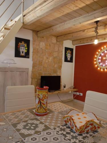 a living room with a table and a desk with a computer at Vicolo San Paolo in Palazzolo Acreide