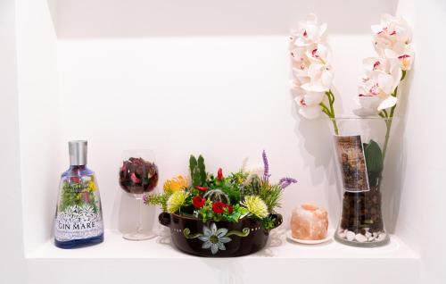 a shelf with vases and flowers and a bottle of wine at La Casa dei Mori in Centuripe