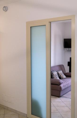 a sliding glass door in a living room with a couch at La Casa dei Mori in Centuripe