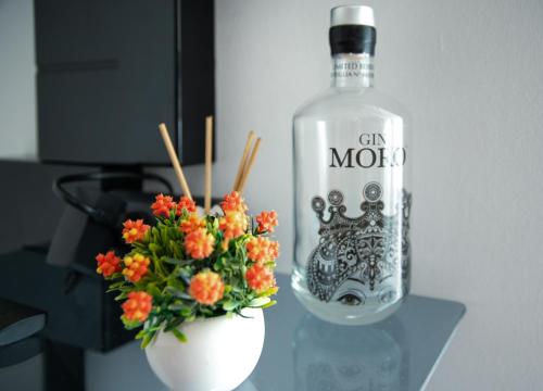 a bottle of vodka sitting next to a vase with flowers at La Casa dei Mori in Centuripe