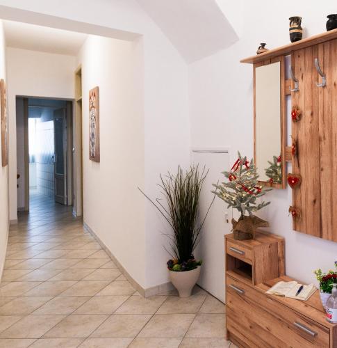 a hallway with a potted plant and a wooden cabinet at La Casa dei Mori in Centuripe