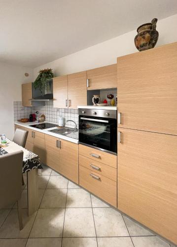 a kitchen with wooden cabinets and a stove top oven at La Casa dei Mori in Centuripe