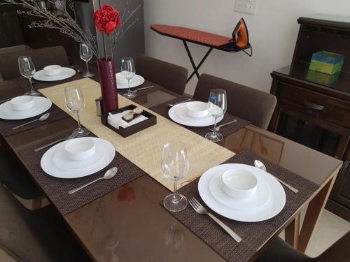 a dining table with white plates and wine glasses at Luxury 3BHK Villa With Private Pool in Candolim in Nerul