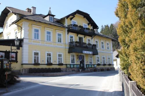 żółty budynek z balkonem na ulicy w obiekcie Kaiserhof w mieście Reichenau an der Rax