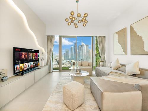 a living room with a couch and a tv at SmartStay at Grande Signature - Burj Khalifa View - 5 min Dubai Mall - Downtown Dubai - Brand New Luxury Apartments in Dubai