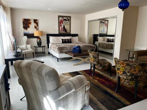 a bedroom with a bed and a couch and chairs at Greenway Manor in Bisbee