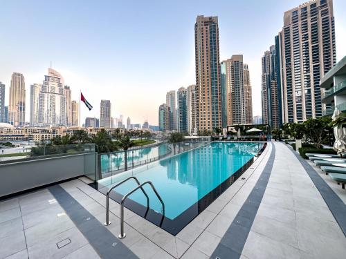 a swimming pool on the roof of a building with a city skyline at SmartStay at Grande Signature - Burj Khalifa View - 5 min Dubai Mall - Downtown Dubai - Brand New Luxury Apartments in Dubai