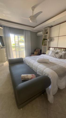 a large bedroom with a large bed and a couch at Sobrado 4 suítes, piscina , para até 12 pessoas 650 metros da praia de Bombinhas in Bombinhas