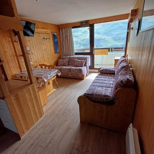 a living room with a couch and a table at Les Menuires Résidence Brelin Skis aux pieds in Les Menuires