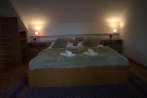 a bedroom with a bed with two slippers on it at Malak Farma in Kakanj