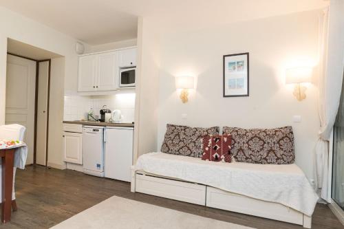 une petite chambre avec un lit et une cuisine dans l'établissement GreenSide, à Deauville