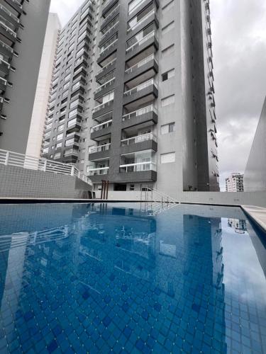 una gran piscina junto a un edificio alto en Unitá Praia Grande Boqueirão, en Praia Grande