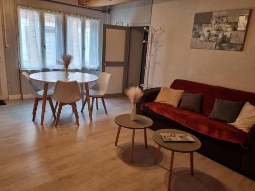 un salon avec un canapé rouge et une table dans l'établissement appartement centre ville, à Salbris