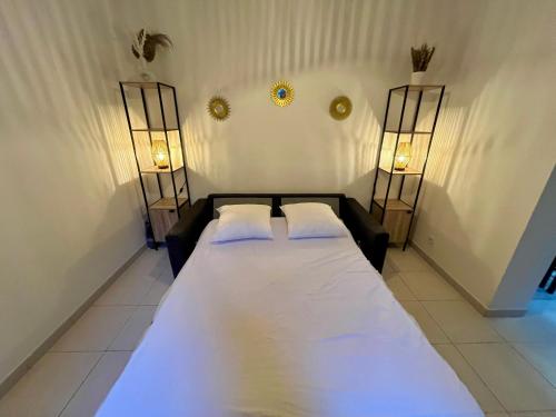 - une chambre avec deux lits et deux lumières sur le mur dans l'établissement studio sommieres, à Sommières