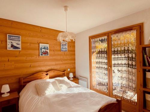 une chambre avec un lit blanc et une fenêtre dans l'établissement Appartement cosy près des pistes avec garage, WIFI, terrasse - La Clusaz - FR-1-459-234, à La Clusaz