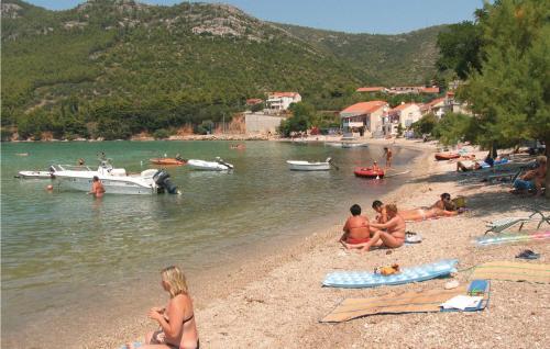 a group of people on a beach with boats in the water at Holiday Home Zuljana 21 in Žuljana