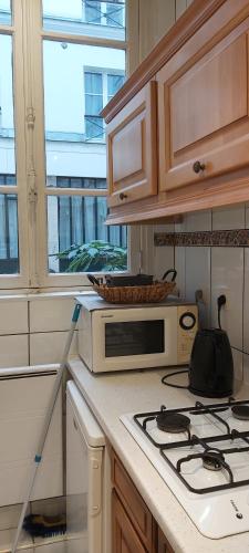 une cuisine avec un micro-ondes et une cuisinière four supérieur dans l'établissement Studio prés du gare du l'Est, à Paris