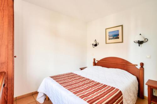 a bedroom with a bed in a white room at Résidence Le Parc d'Arradoy - maeva Home - Appartement 2 pièces 5 personnes - Sélection MAE-2344 in Uhart-Cize