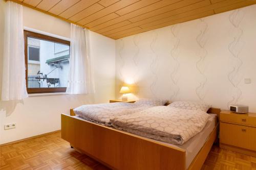 a bedroom with a bed and a window at Ferienwohnung Bender in Sinsheim