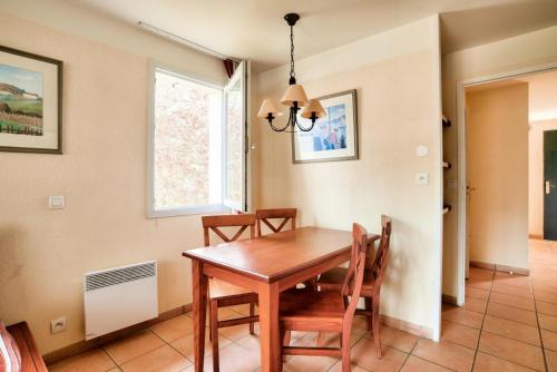 a dining room with a wooden table and chairs at Résidence Le Parc d'Arradoy - maeva Home - Appartement 2 pièces 5 personnes - Sélection MAE-2374 in Uhart-Cize