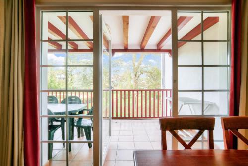 an open door to a balcony with a table at Résidence Le Parc d'Arradoy - maeva Home - Appartement 3 pièces 6 personnes - Confort MAE-1881 in Uhart-Cize