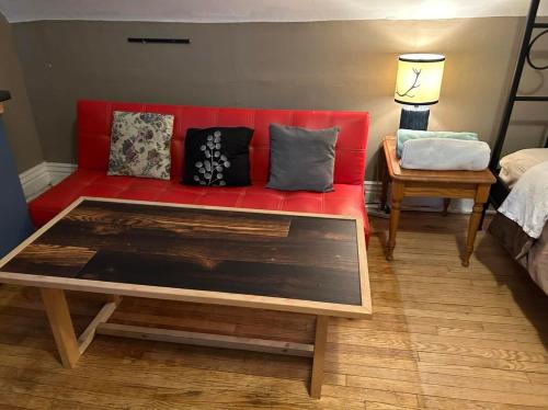 a red couch with pillows on it in a room at Maryland Homestay in Winnpeg downtown in Winnipeg