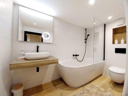 a bathroom with a tub and a sink and a toilet at L'underground - parking - jardin in Huningue