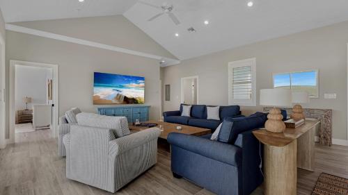 a living room with blue couches and a table at Oceanfront Oasis by Last Key Realty in Key West