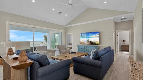 a living room with two blue couches and a table at Oceanfront Oasis by Last Key Realty in Key West