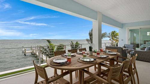 a dining room with a table and chairs and the ocean at Oceanfront Oasis by Last Key Realty in Key West