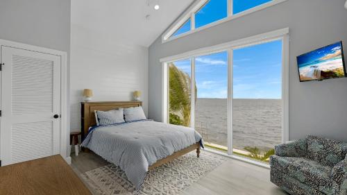 a bedroom with a bed and a large window at Oceanfront Oasis by Last Key Realty in Key West