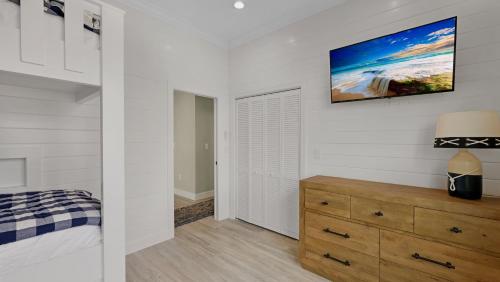 a bedroom with a dresser and a tv on the wall at Oceanfront Oasis by Last Key Realty in Key West