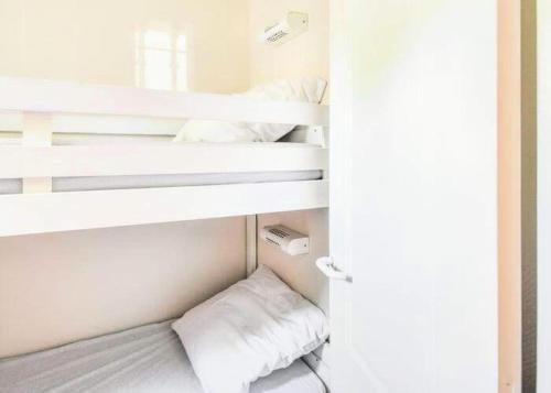 - une chambre avec 2 lits superposés aux murs blancs dans l'établissement Village Pont Royal en Provence - maeva Home - Appartement cosy climatisé 2 pièces 6 personnes - Sélection - super Home MAE-1791, à Mallemort
