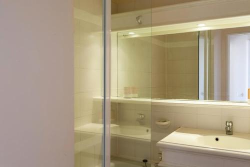 une salle de bain blanche avec un lavabo et un miroir dans l'établissement Village Pont Royal en Provence - maeva Home - Appartement cosy climatisé 2 pièces 6 personnes - Sélection - super Home MAE-1791, à Mallemort