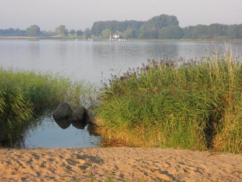 a view of a lake with some grass and water at Schlei Resort Marina Hülsen in Kosel