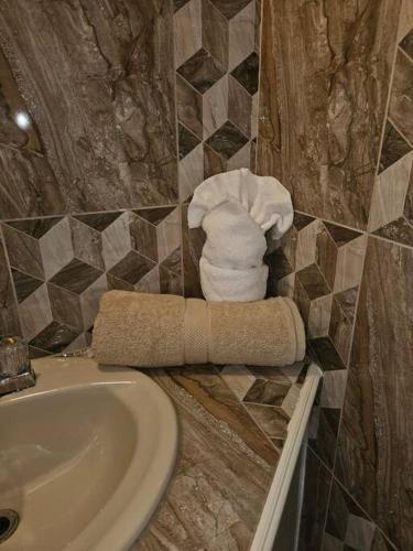 a bathroom with a sink and a pile of towels at Jardin Damon in Soufrière