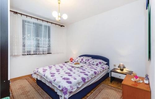 ein Schlafzimmer mit einem blauen Bett und einem Fenster in der Unterkunft Nice Apartment In Novi Vinodolski in Novi Vinodolski