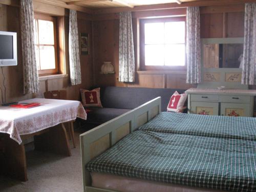 1 dormitorio con cama, escritorio y ventana en Malernhof, en Kitzbühel